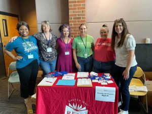 Ignite Conference Photo - Women standing at presenter and volunteer sign-in table